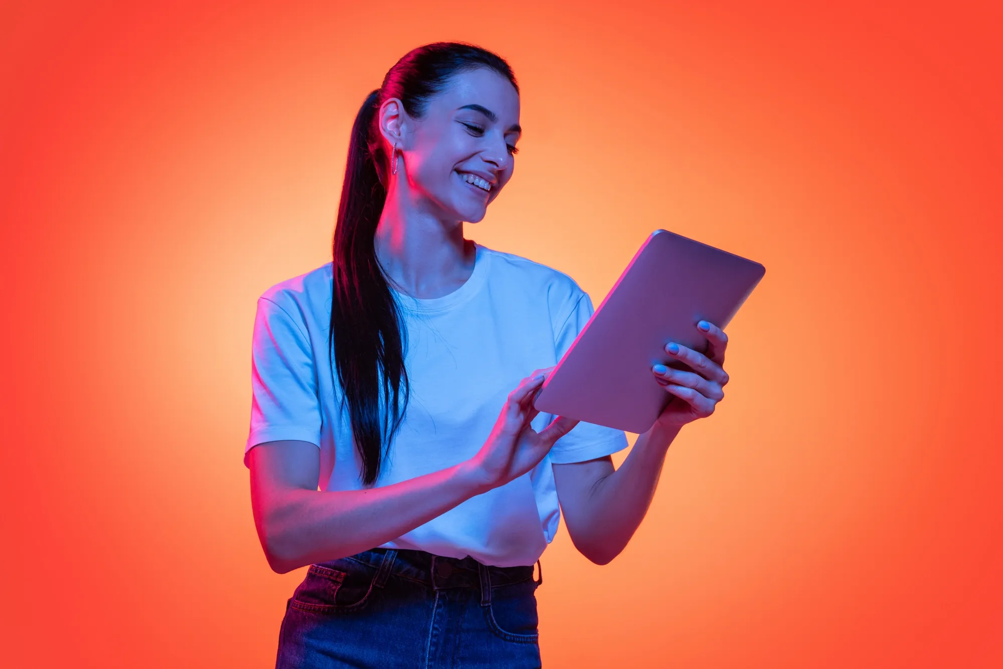 A woman smiling while reading her SOURCECODE daily briefing on a tablet, lit in orange